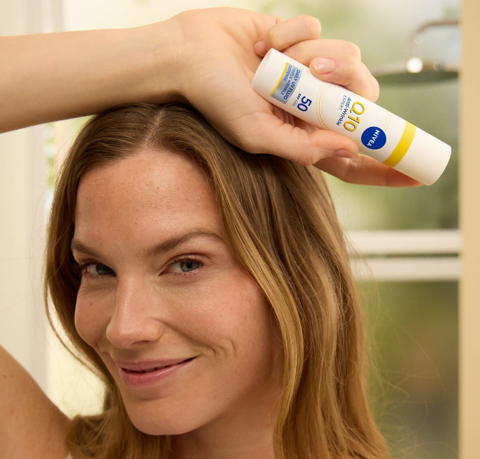 Frau, die Nivea Q10 Anti-Falten EXPERT DAILY UV FLUID SPF 50 verwendet