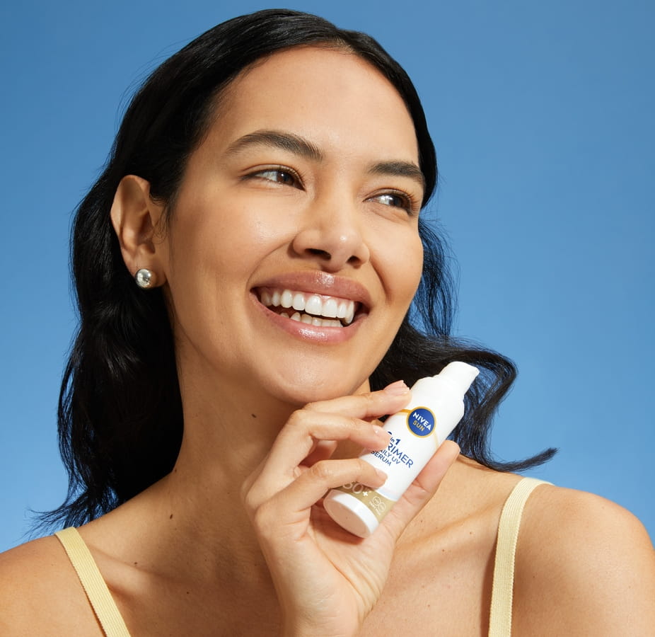 Jeune femme utilisant NIVEA SUN 2In1 Primer UV Serum SPF 50+
