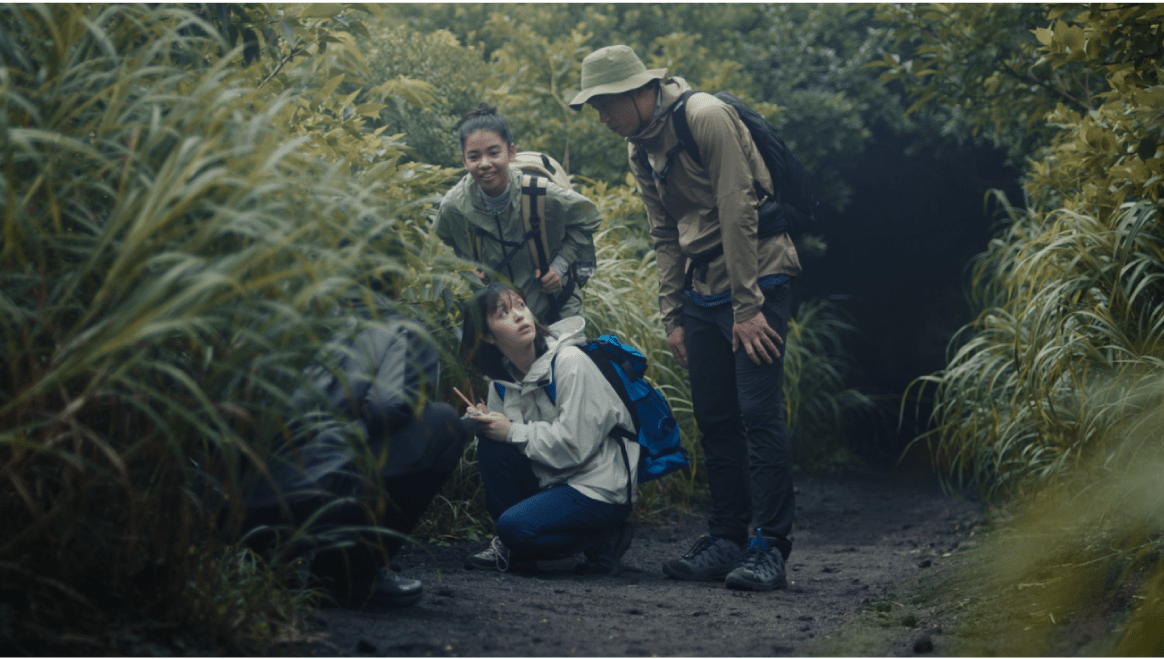 草木が茂る道でフィールドワークする豊嶋花と仲間たち