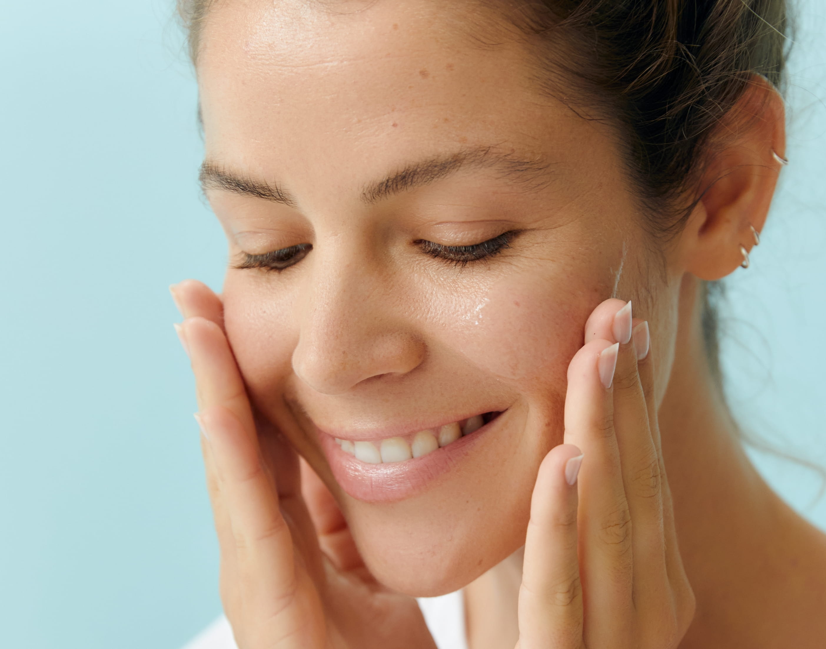 person ler och rengör sitt ansikte med händerna