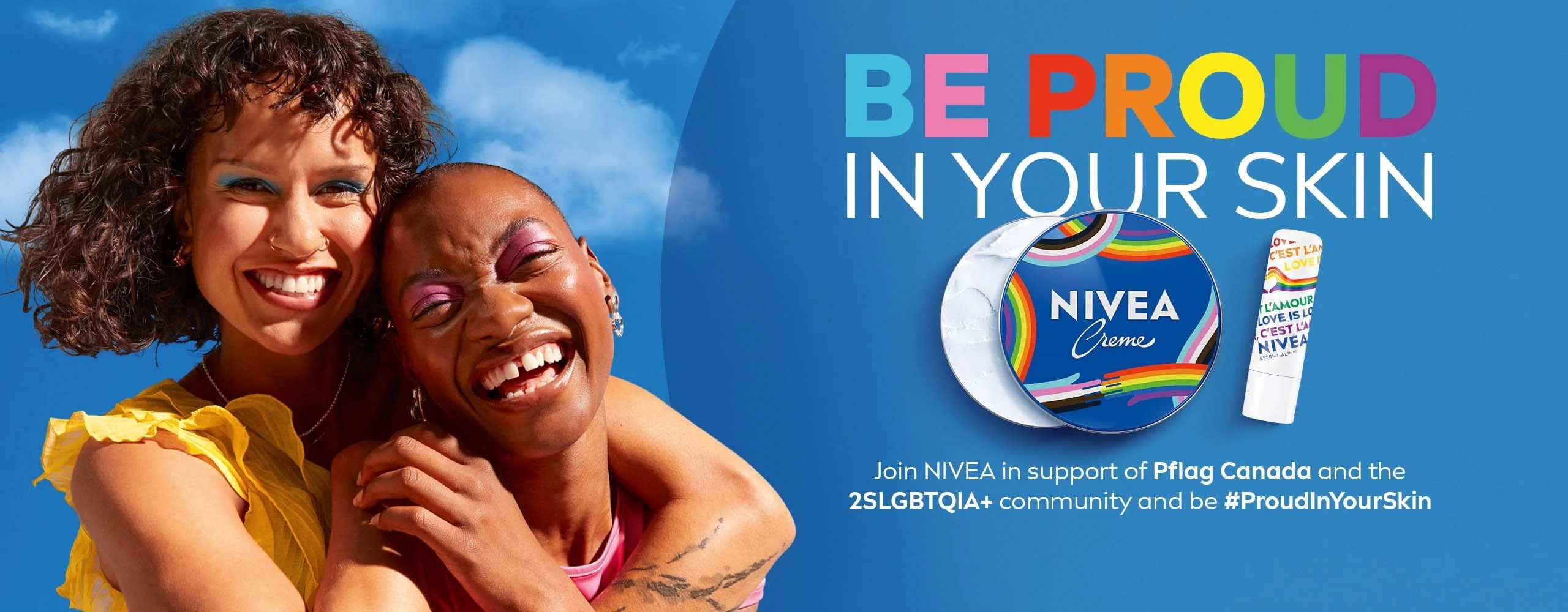 Two smiling people embrace against a blue sky. Limited edition NIVEA Pride Creme tin and Essential Lip Balm promoting the "Be Proud in Your Skin" campaign in support of the 2SLGBTQIA+ community.