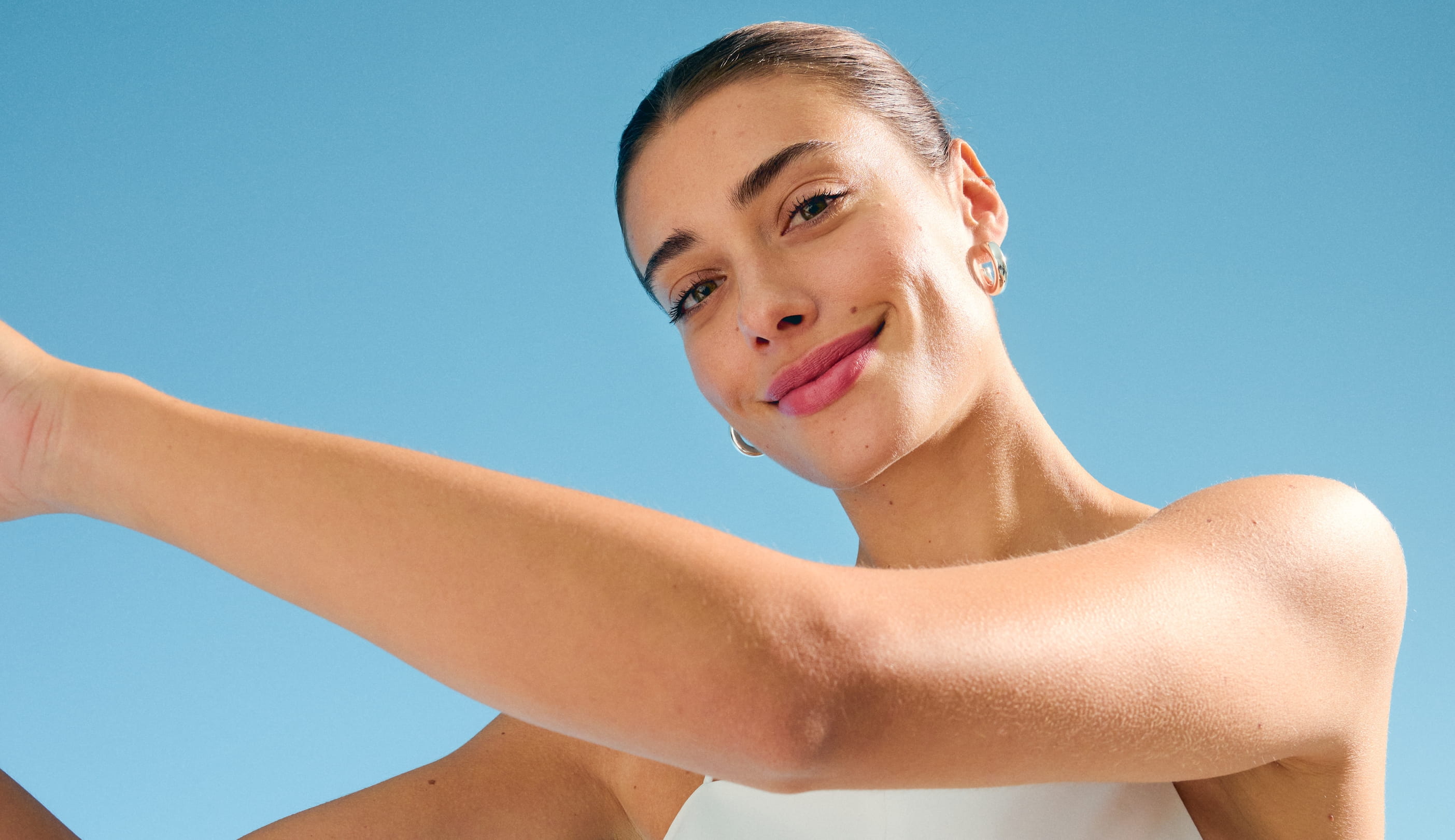 kvinna som ler framför kameran och sträcker ut armarna till vänster