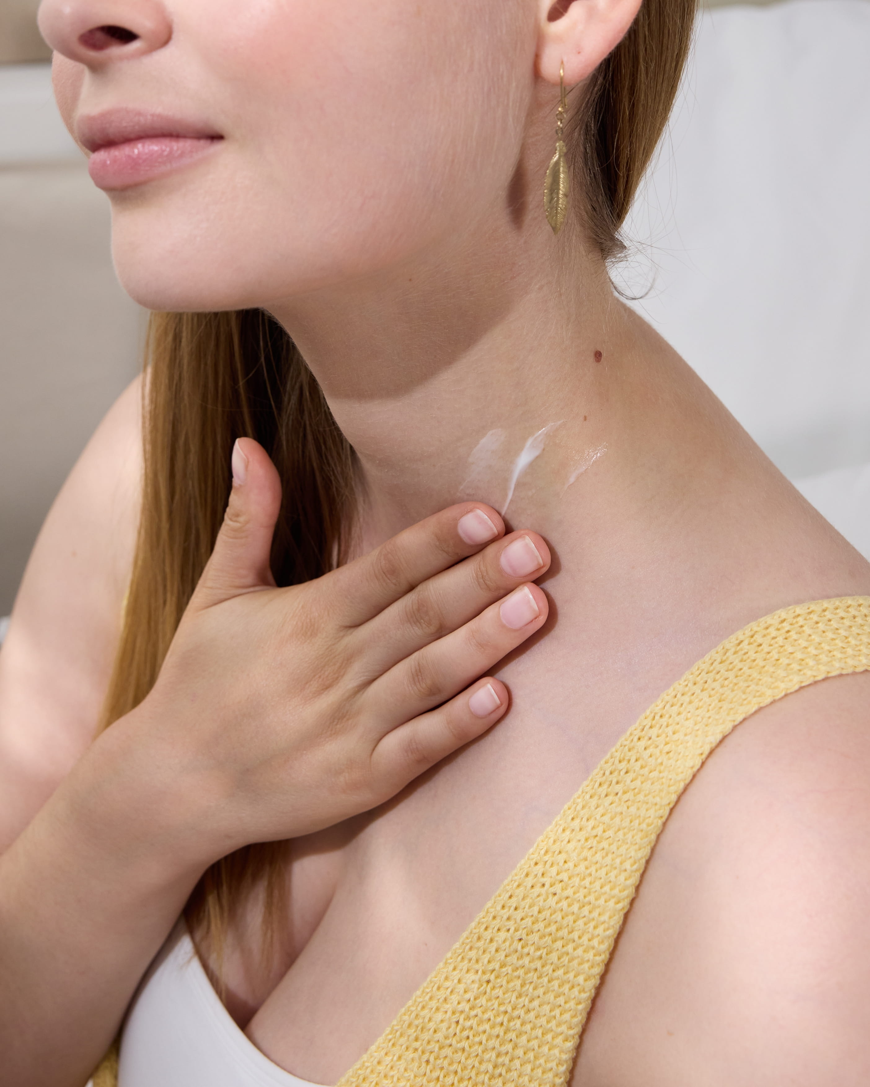 Dame trägt Creme auf ihren Hals auf