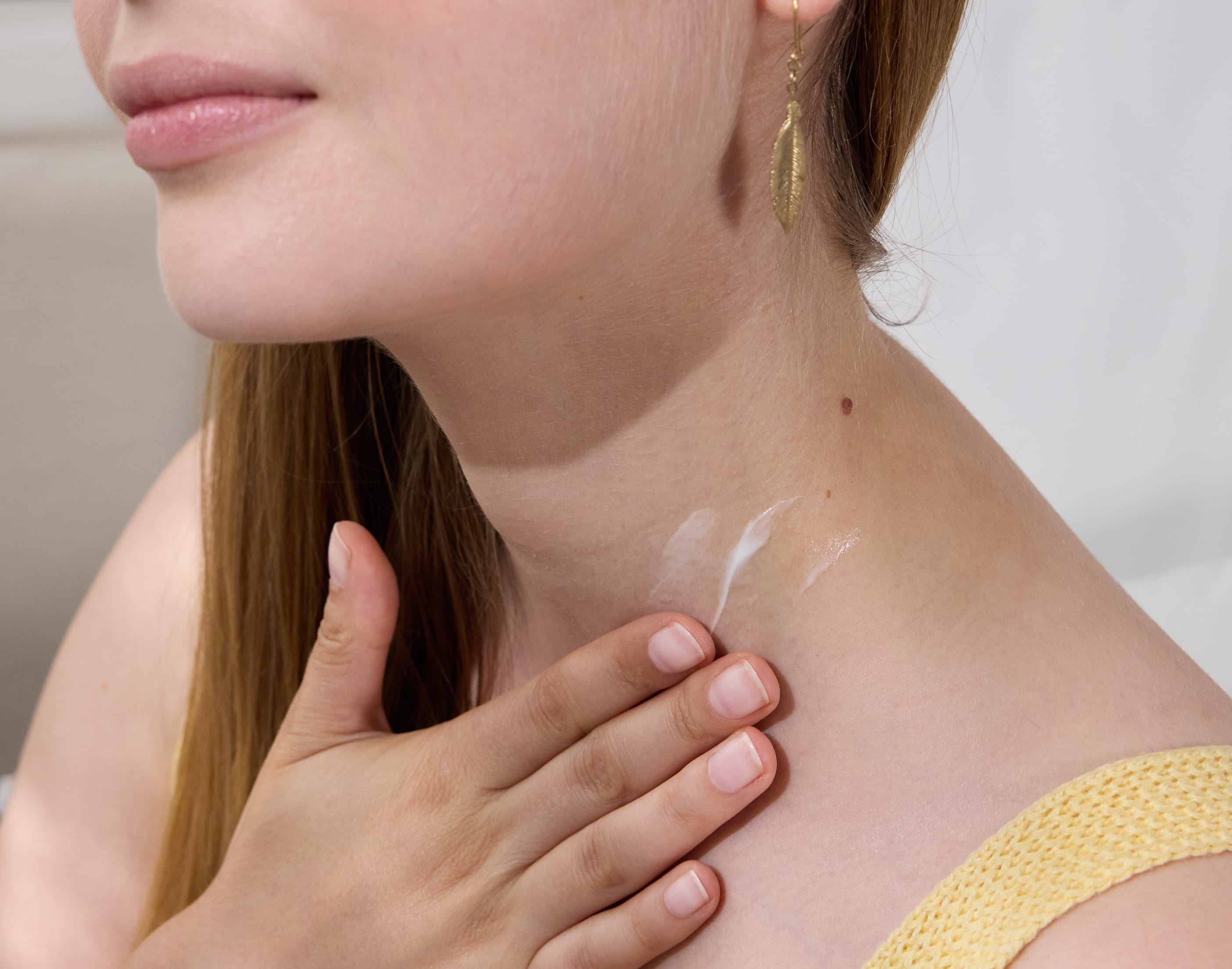 Dame trägt Creme auf ihren Hals auf