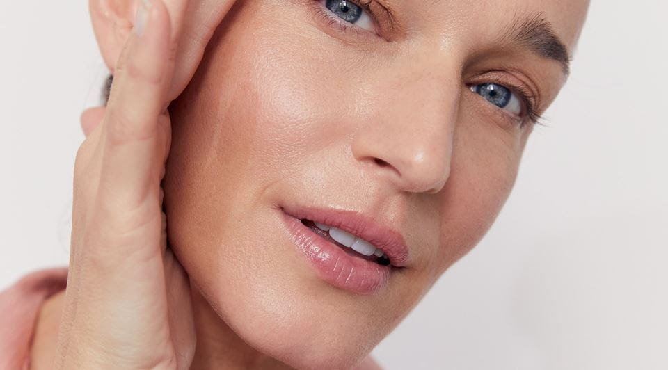 kobieta stosująca krem do twarzy