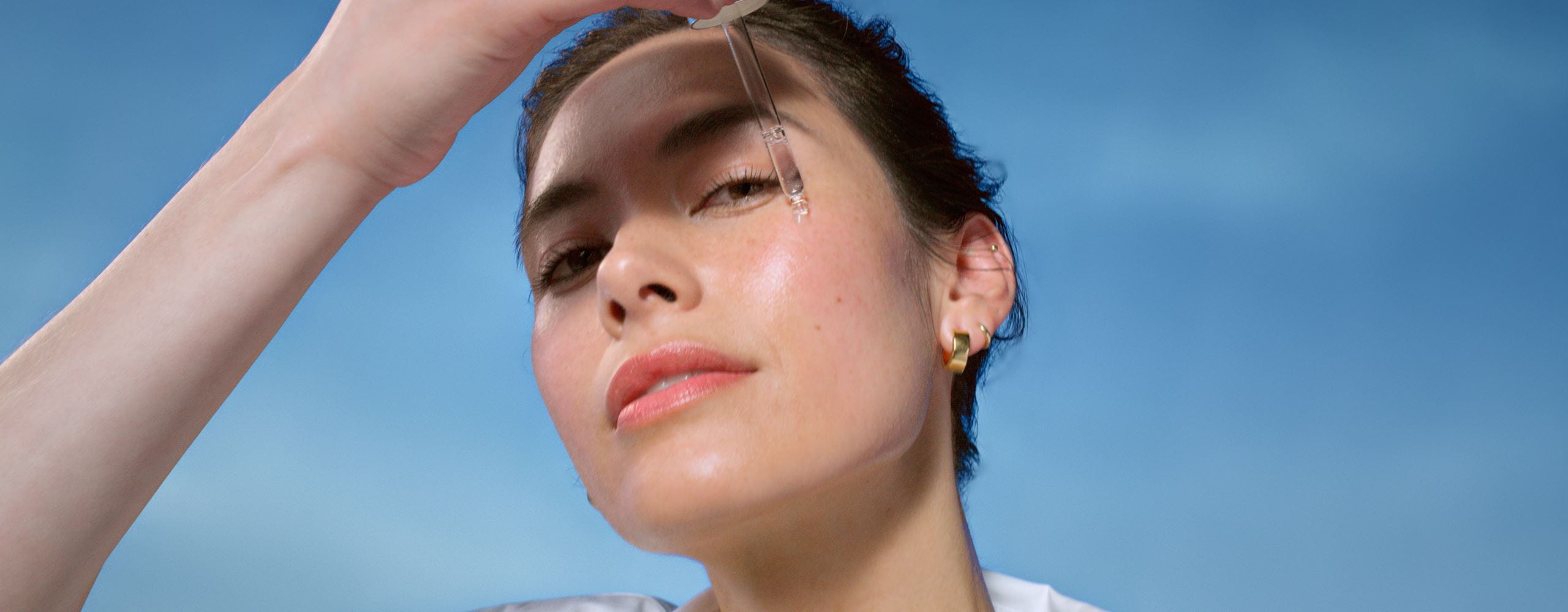 Woman applying face serum