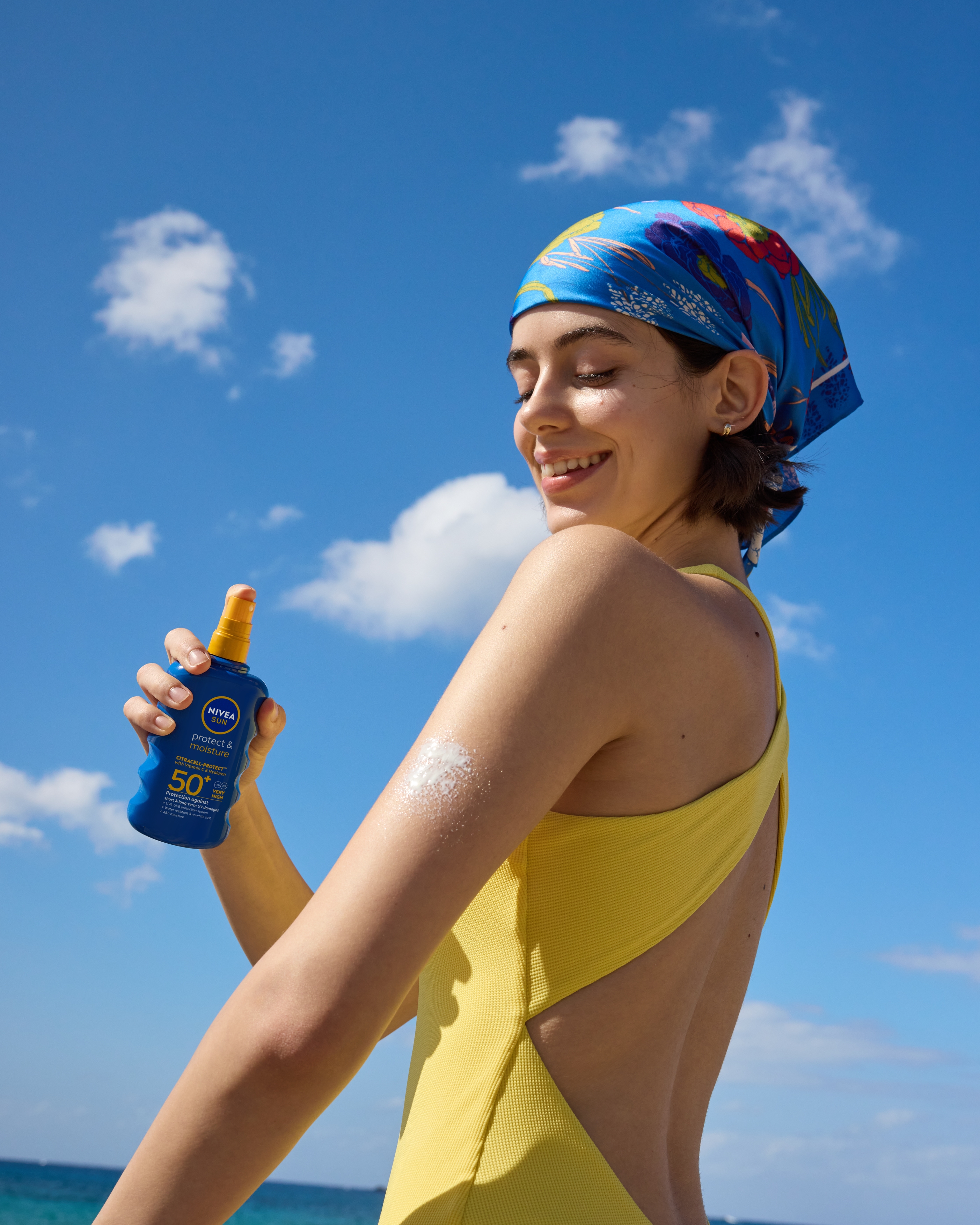 tjej smörjer in sig med NIVEA solspray SPF 50+