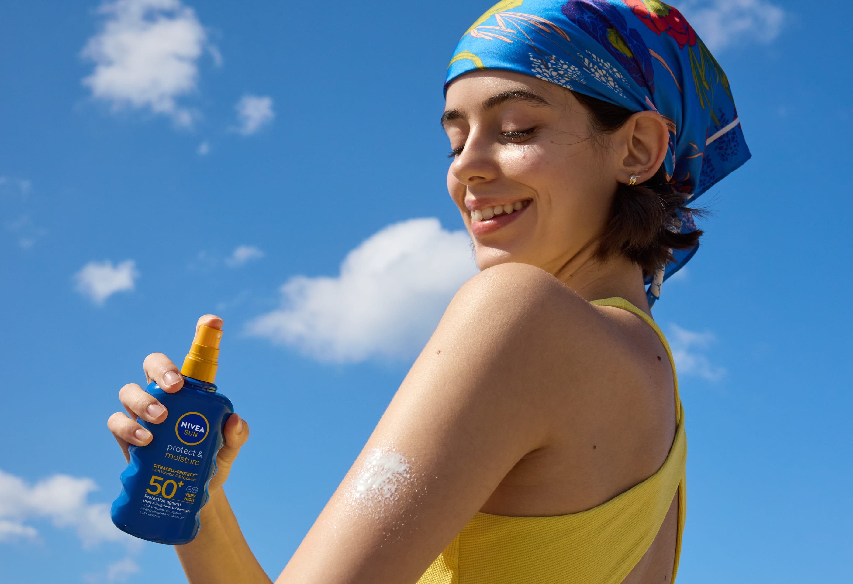 tjej smörjer in sig med NIVEA solspray SPF 50+