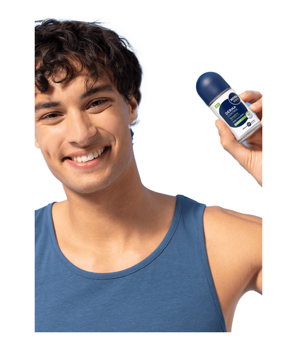 A young smiling man smiles while holding up NIVEA MEN Derma Control Sensitive Deo Roll-On.