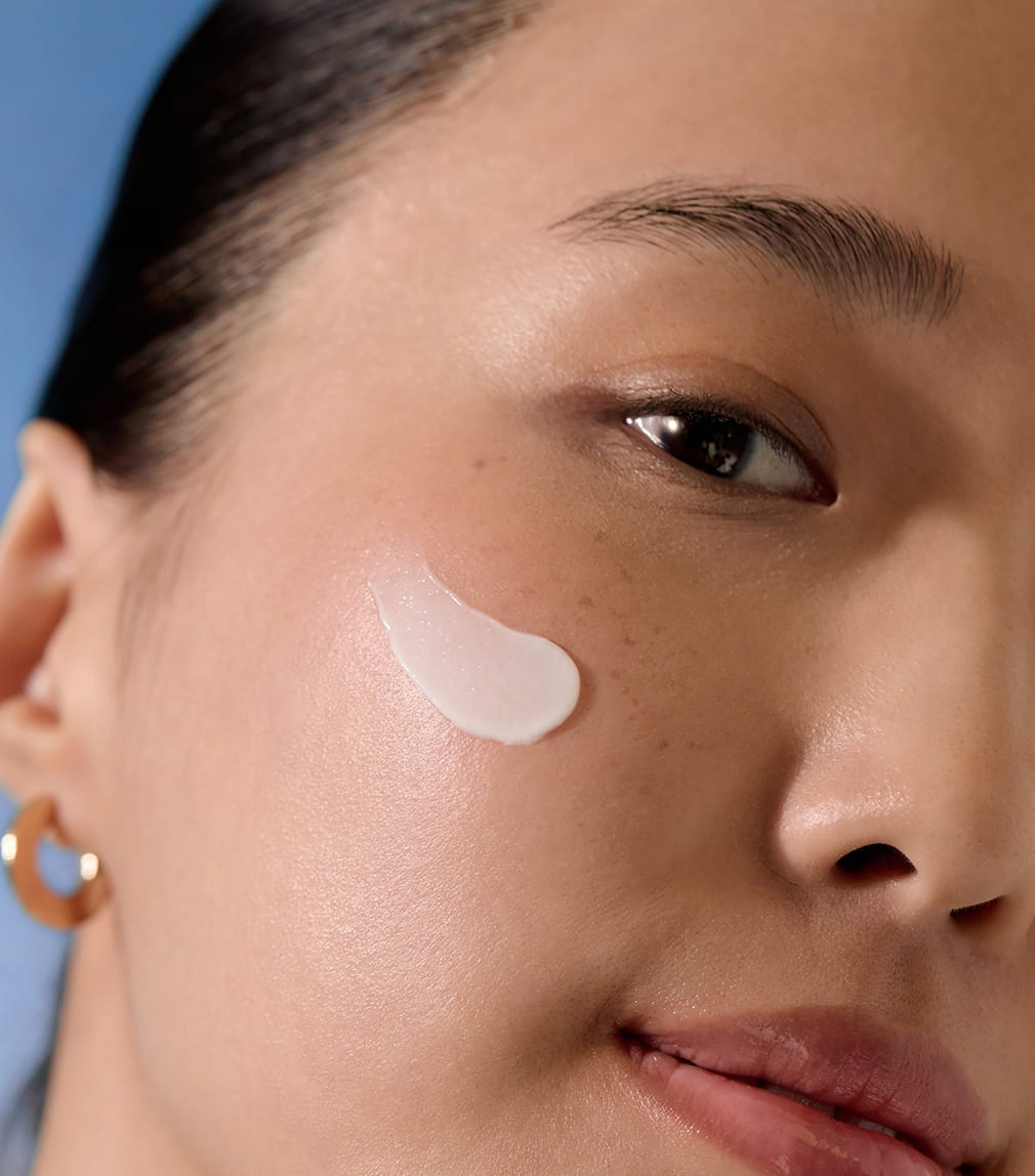 Frau, die Nivea-Creme auf ihr Knie aufträgt