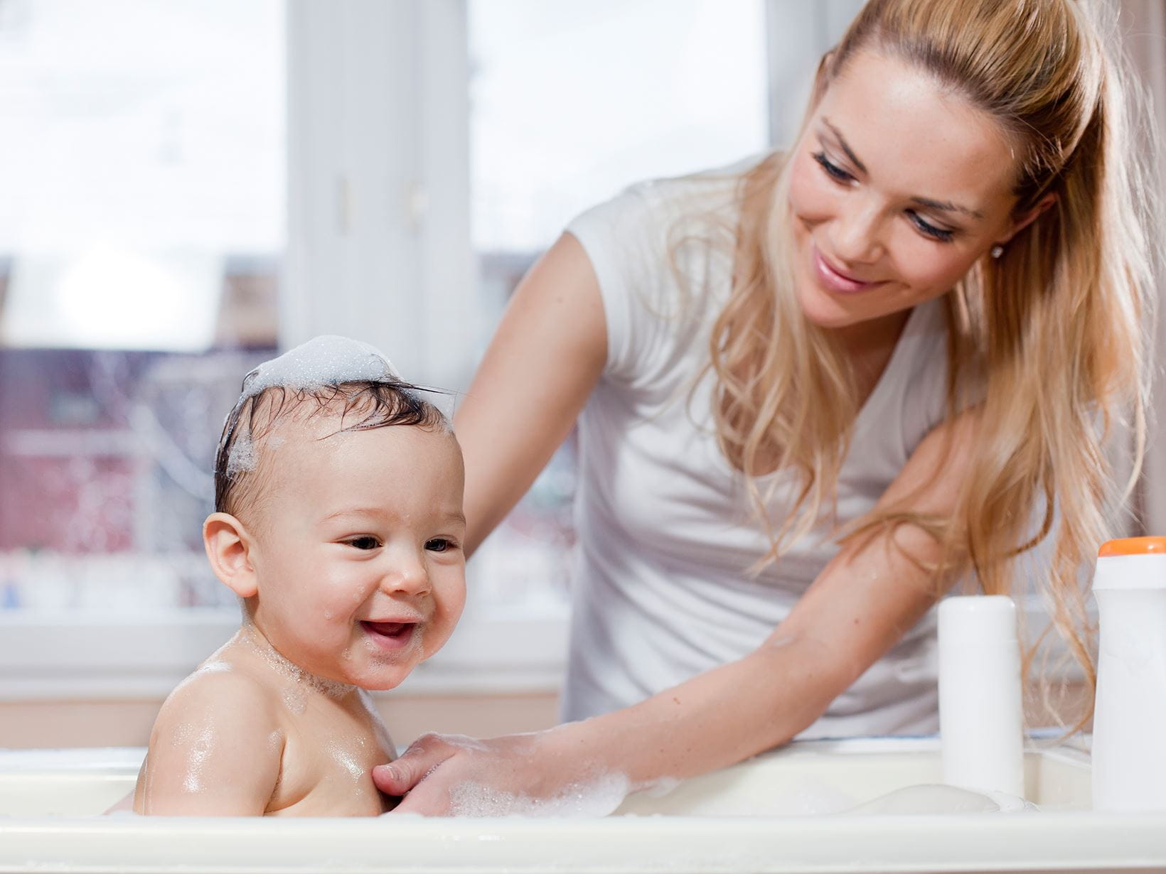 Une maman qui baigne son bébé