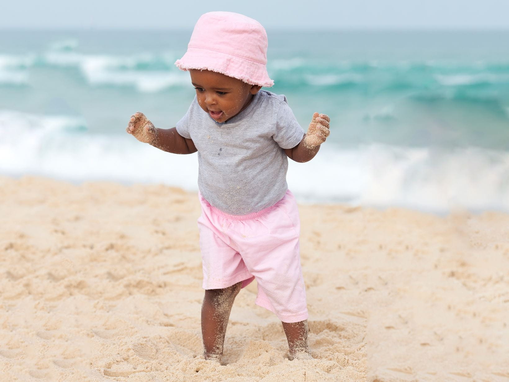 bébé-à-la-plage-avec-son-chapeau