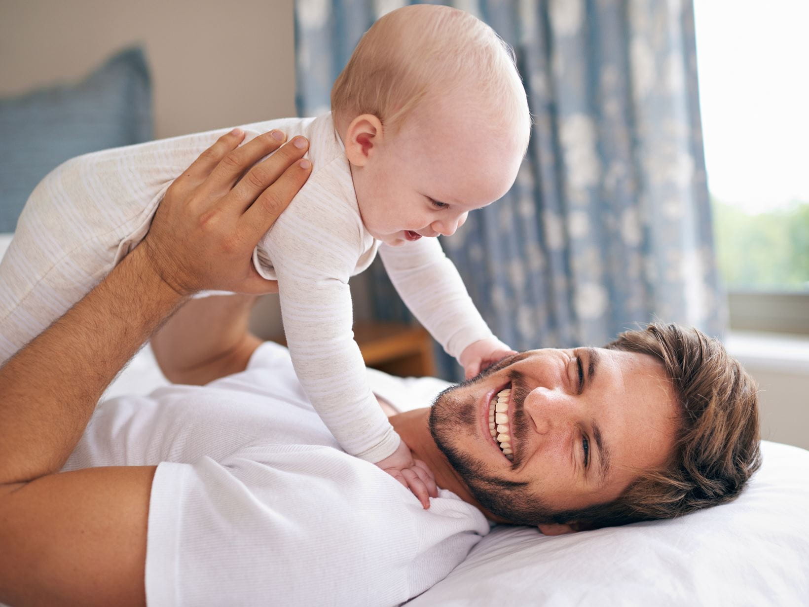 papa-portant-son-bébé-et-souriant