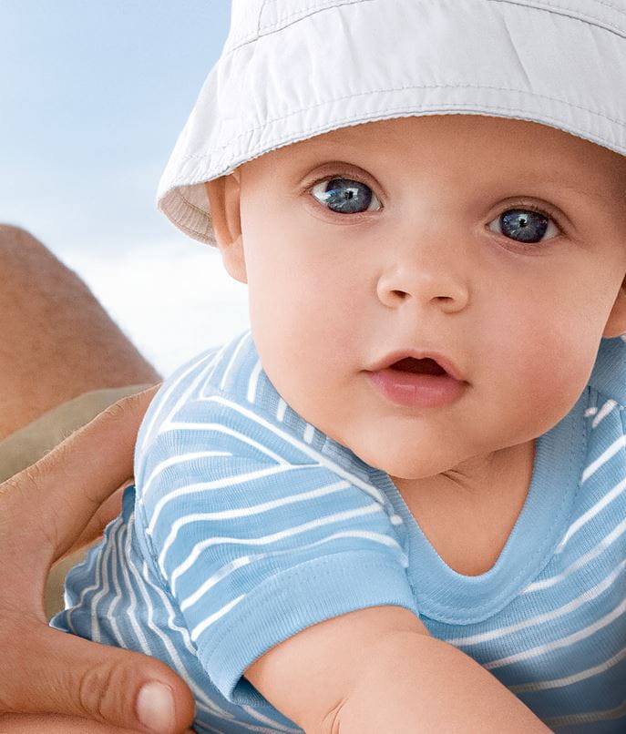 bebé ao colo do pai na praia