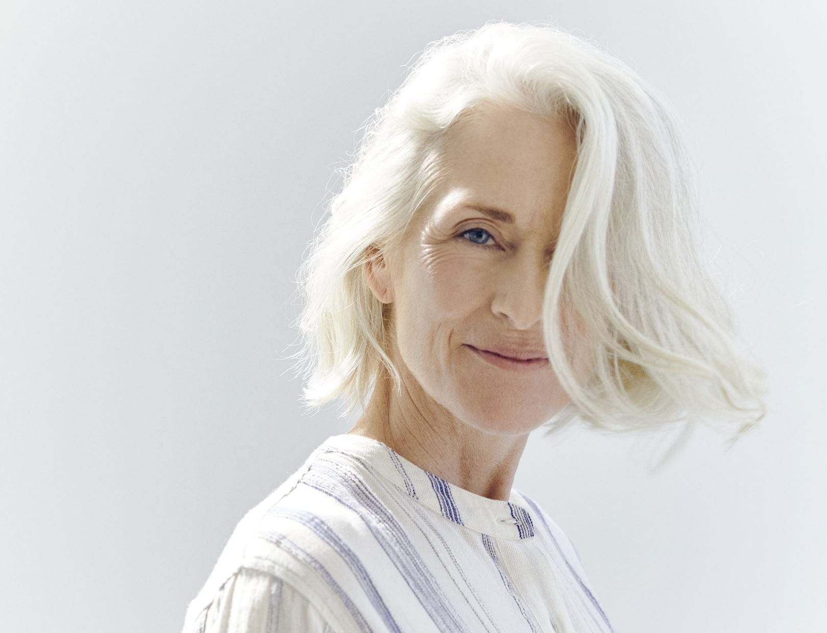 mulher com cabelo branco e manchas de idade