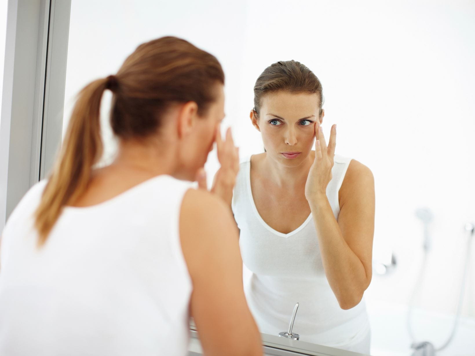 woman-skincare-in-front-of-bathroom-mirror