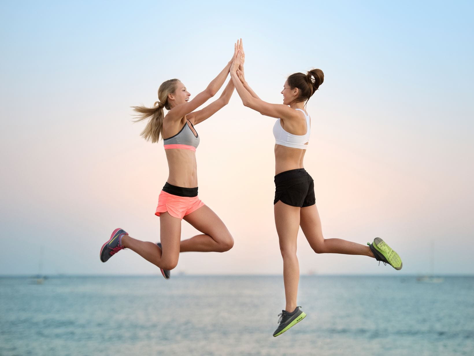 women-jumping-high-five