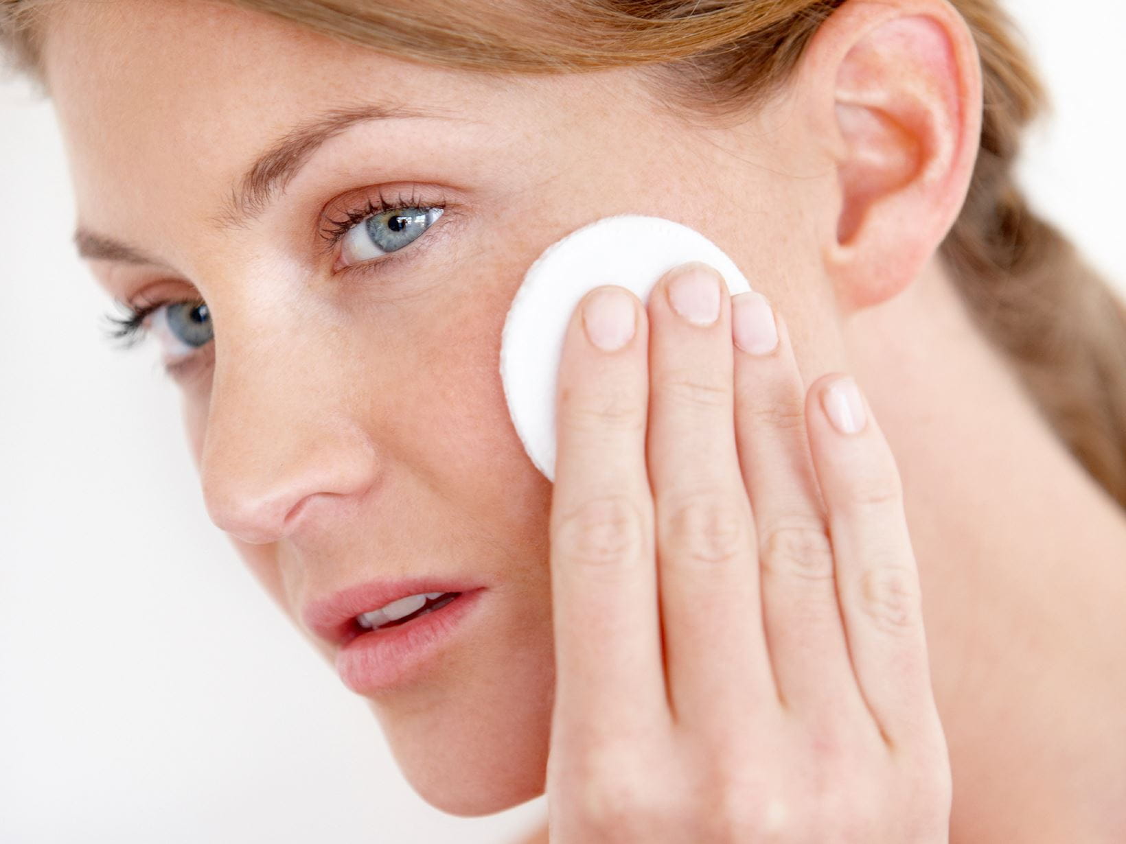 woman exfoliating her face