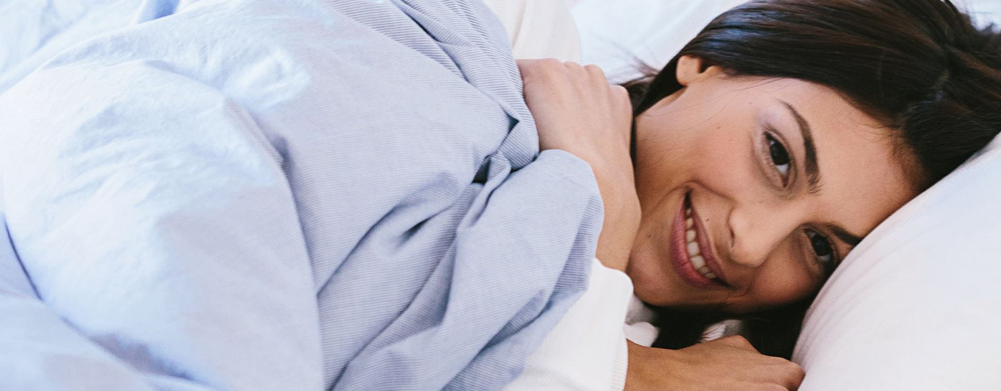 Femme dans le lit avec couverture bleu