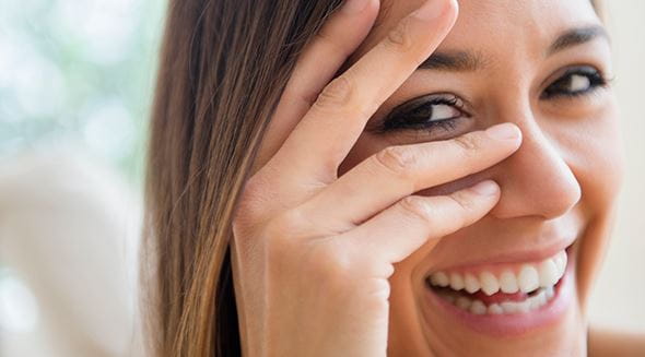 Mulher a esconder o rosto com a mão