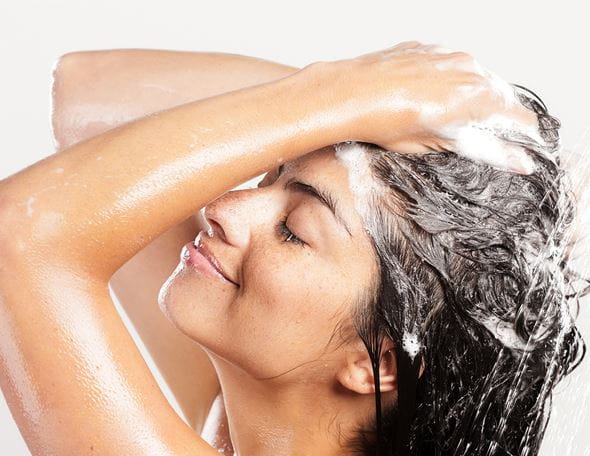 Femme se lave cheveux sous la douche