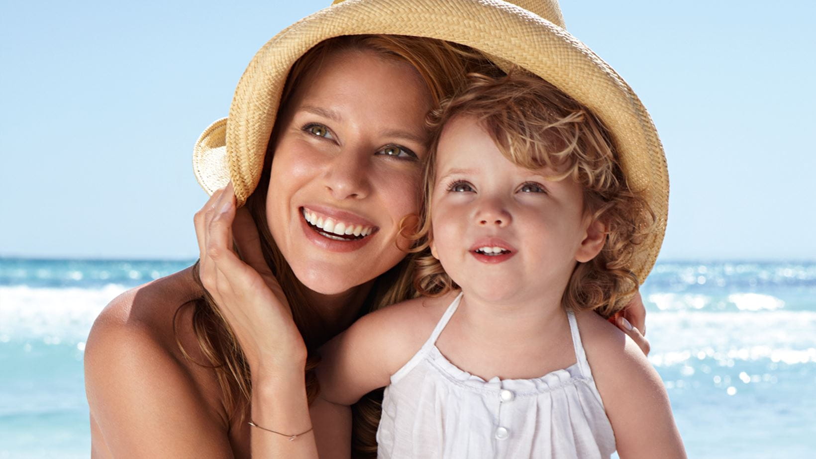 woman caring for daughter with childrens sun cream