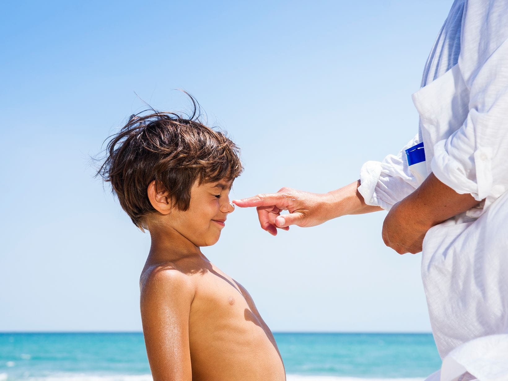 woman applying best childrens sun cream on son