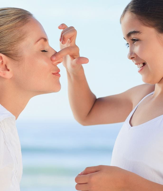 Kindje smeert crème op neus van mama