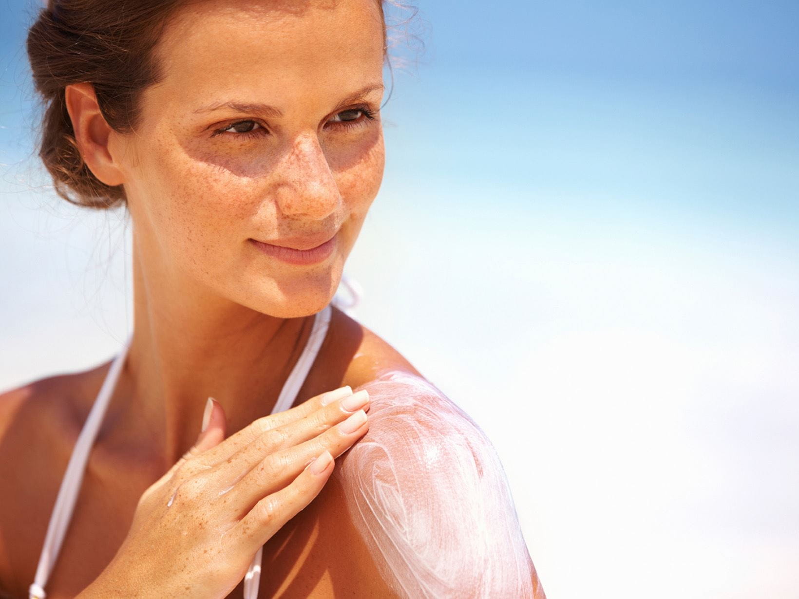 woman applying sunscreen to her shoulder