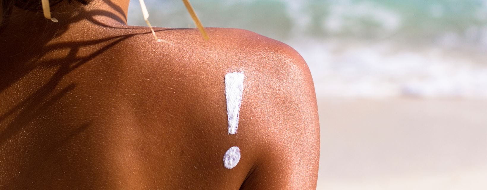 mulher com chapéu e protetor solar