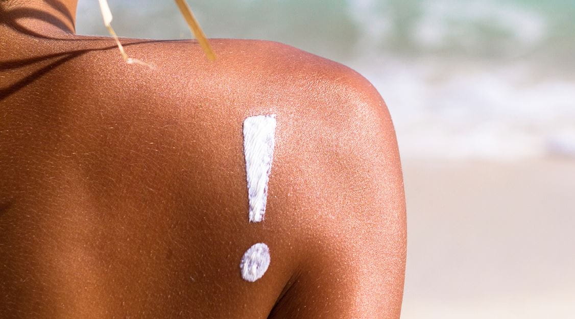 mulher com chapéu e protetor solar