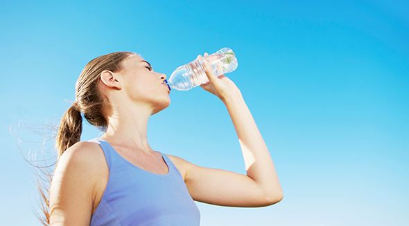 Frau trinkt aus einer Wasserflasche