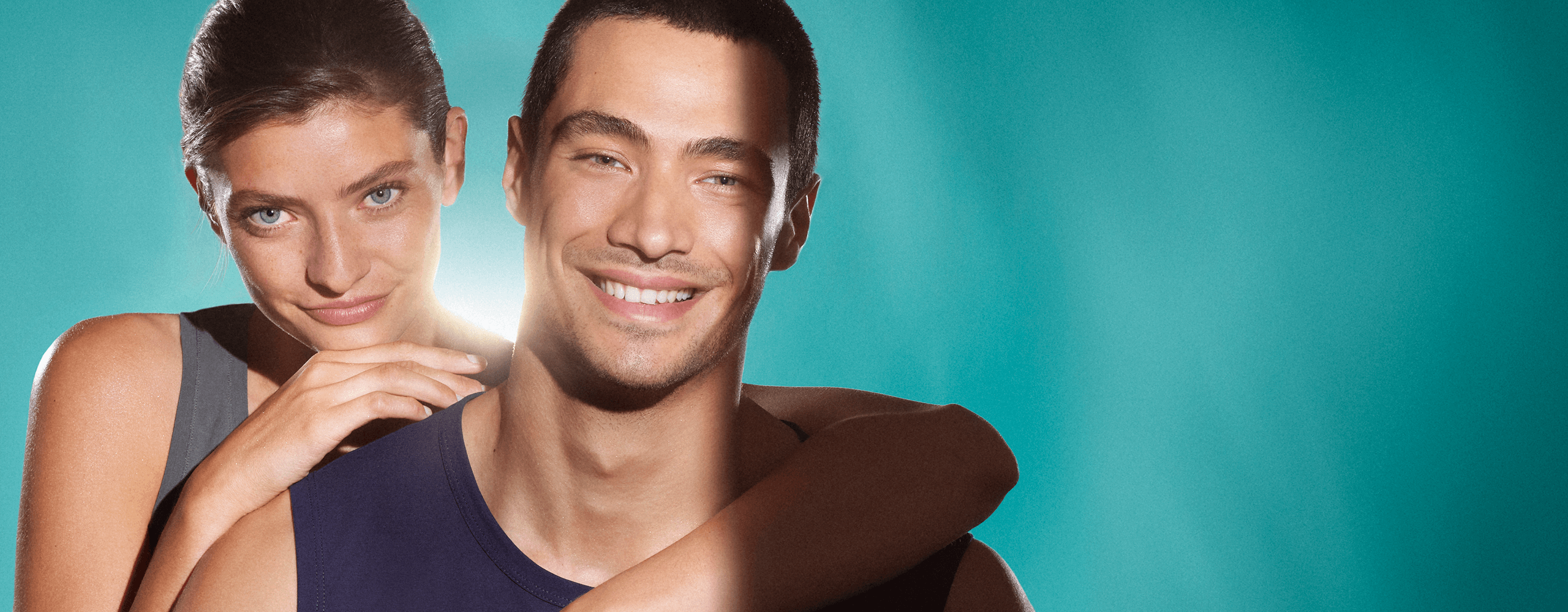 Medium close up of a woman and man, both of their faces show clear, blemish-free skin. They
