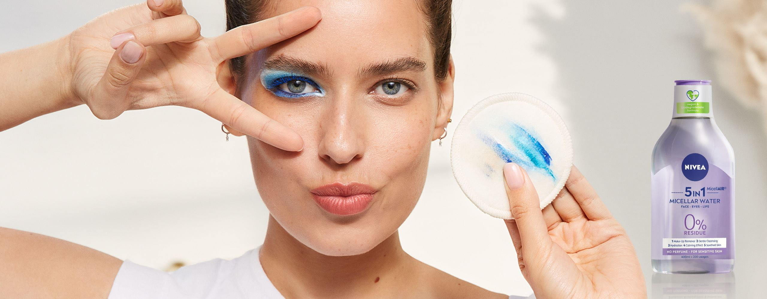 mulher com disco de algodão a remover a maquilhagem com água micelar
