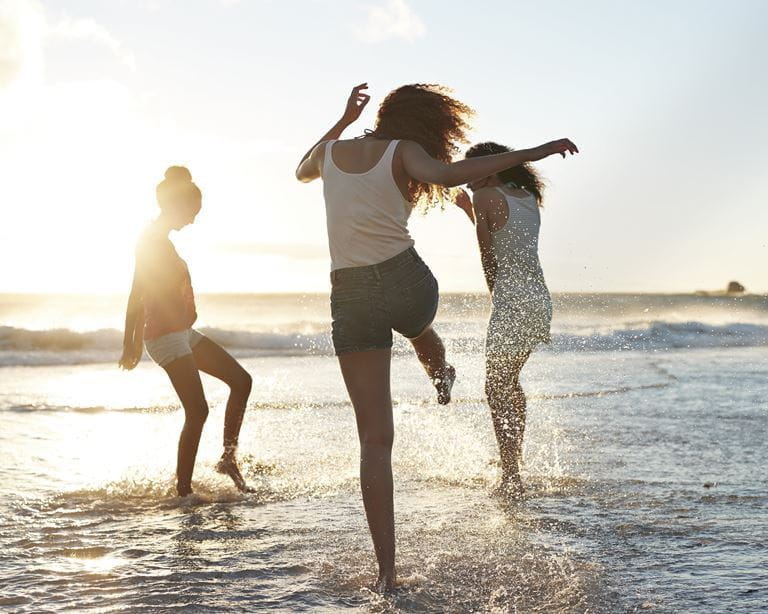 mulheres a brincar à beira mar