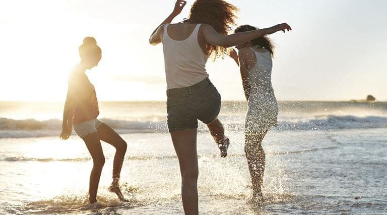 mulheres a brincar à beira mar