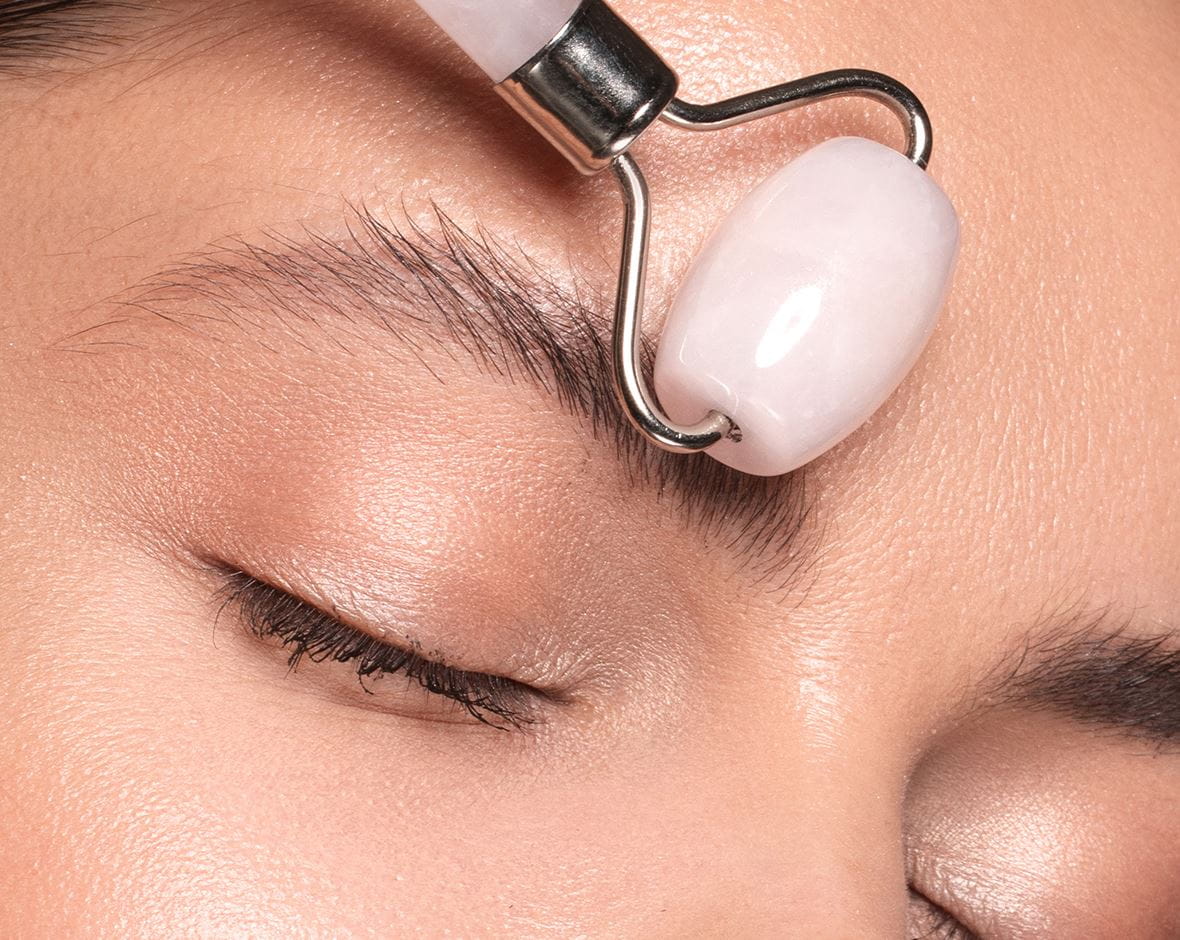 mujer aplicándose rodillo facial