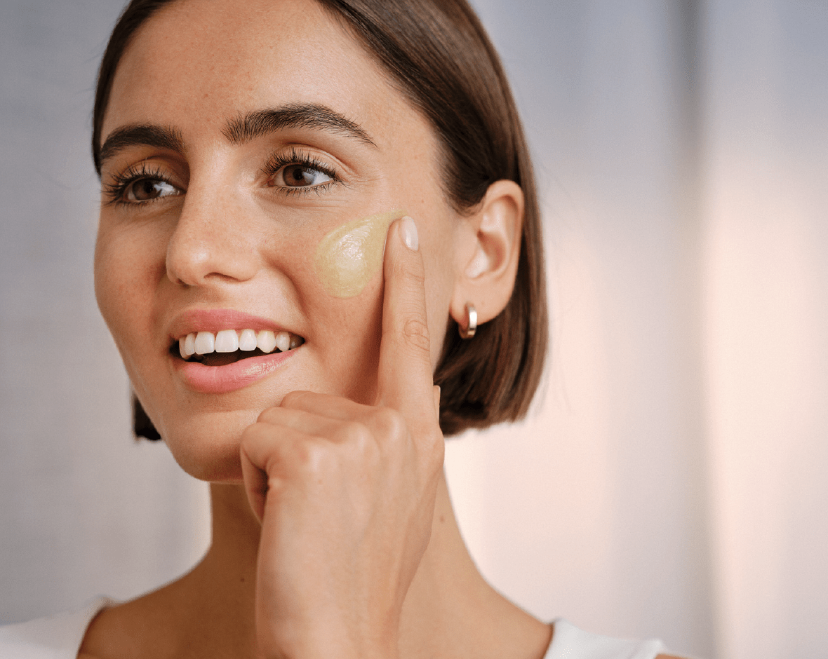 Persona poniéndose crema matificante en la cara