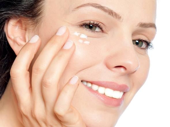 woman patting in eye cream