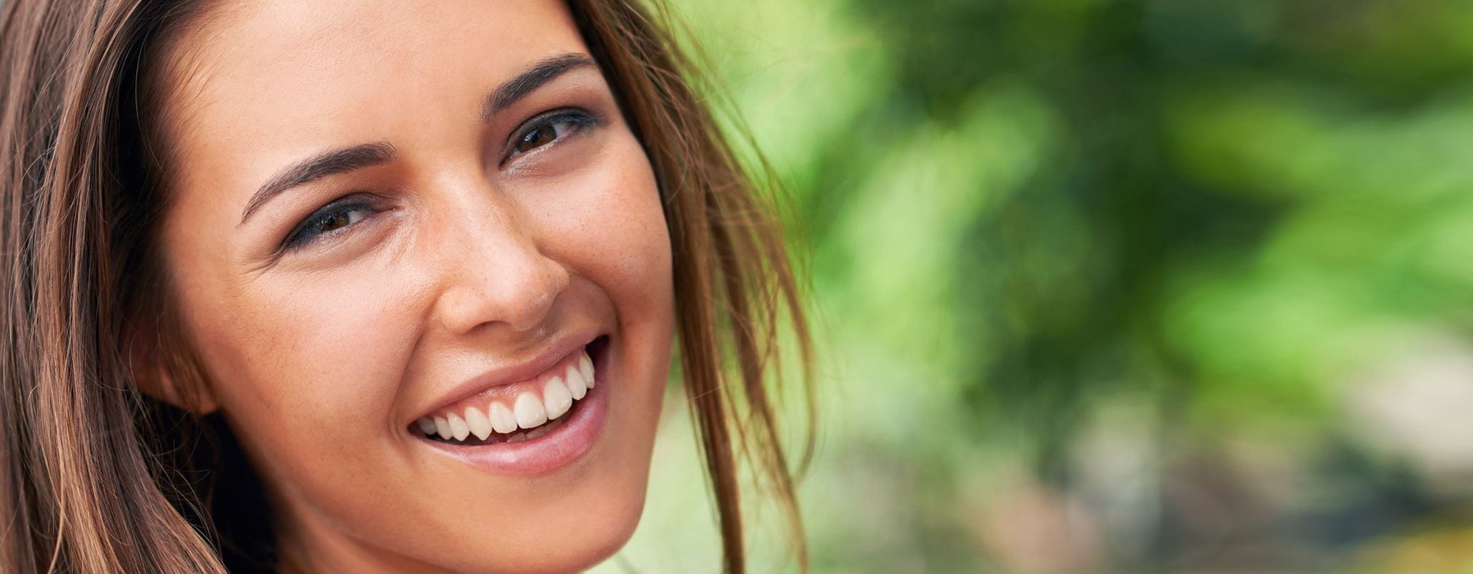 Femme brune rigole avec fond vert