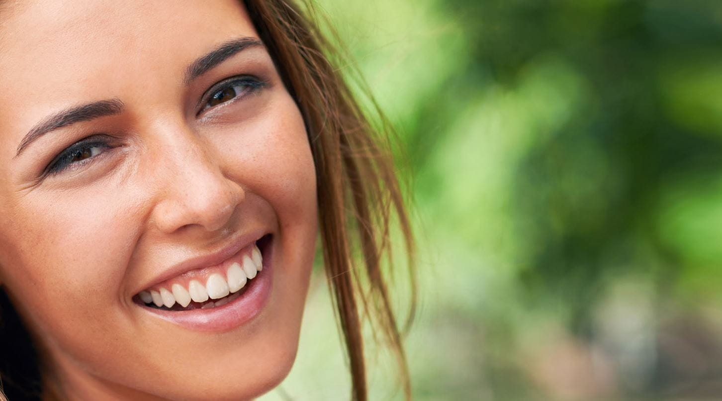 Femme brune rigole avec fond vert