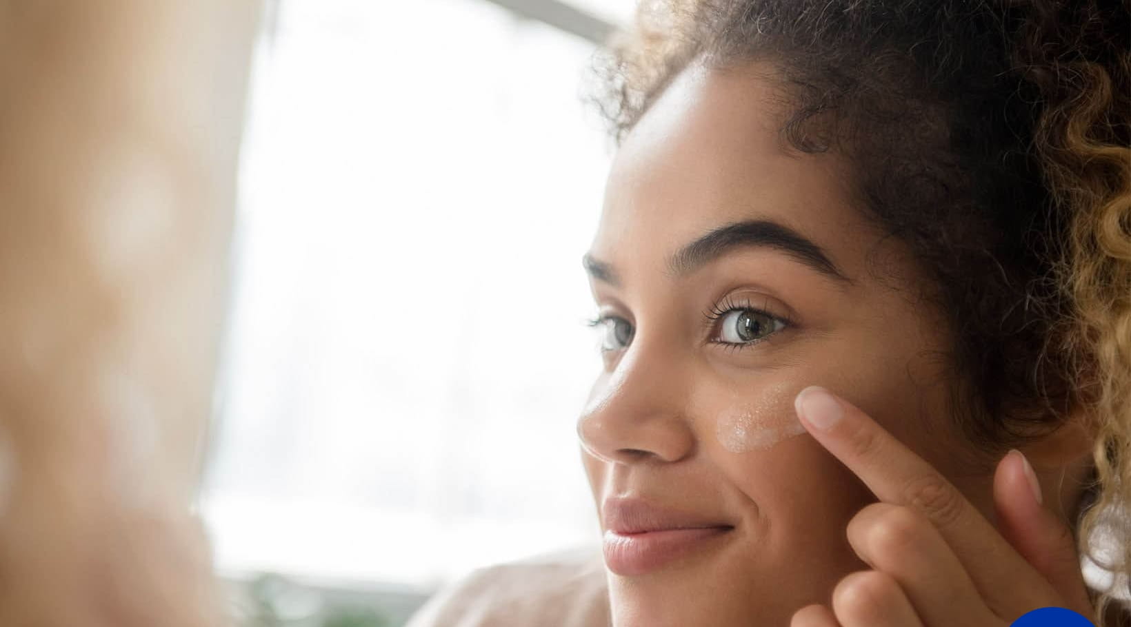 жена, нанасяща серум върху лицето си