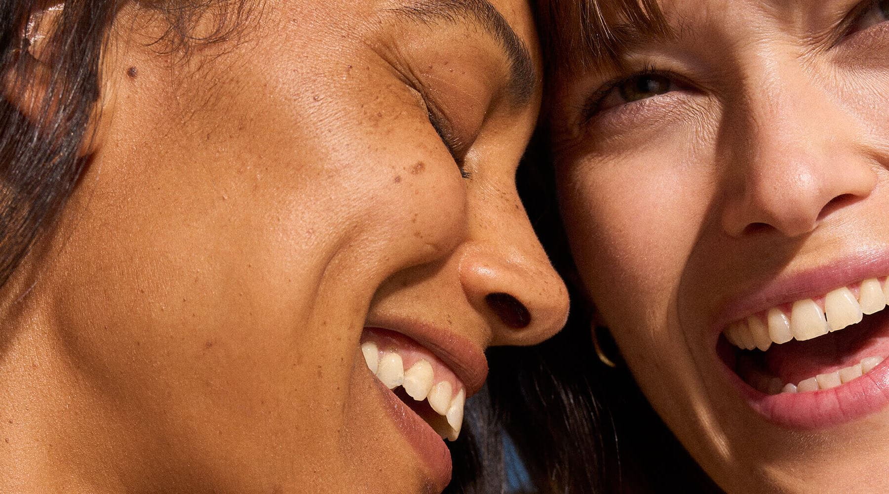 A view of two people's faces closely touching together while smiling.
