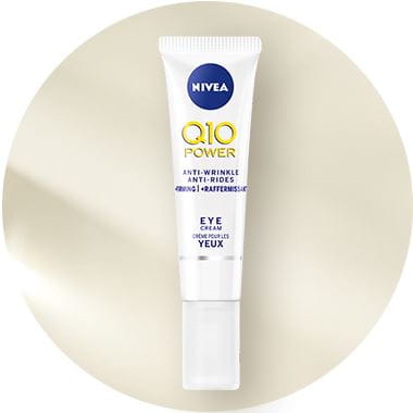 View of a Nivea Q10 Power eye cream product against a beige background.