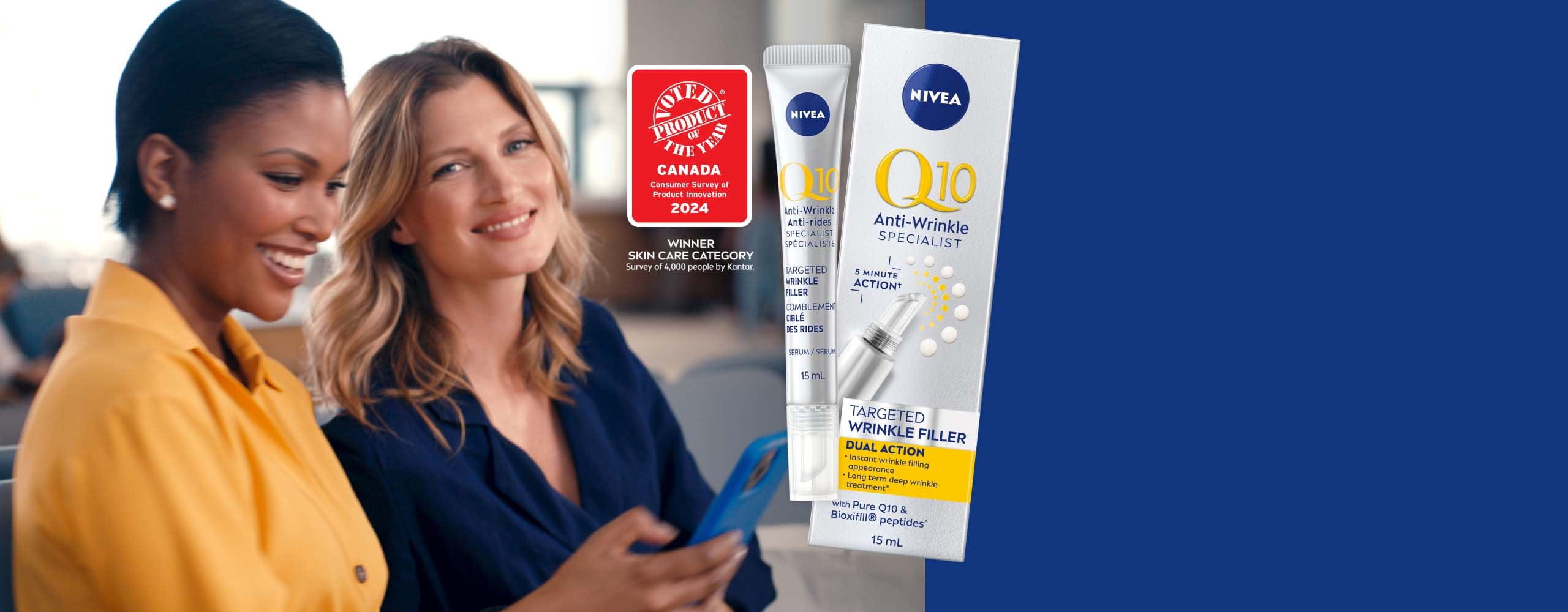 View of two female models smiling while holding a cell phone with the Nivea Q10 Anti Wrinkle Specialist targeted wrinkle filler product placed over top a blue background. 