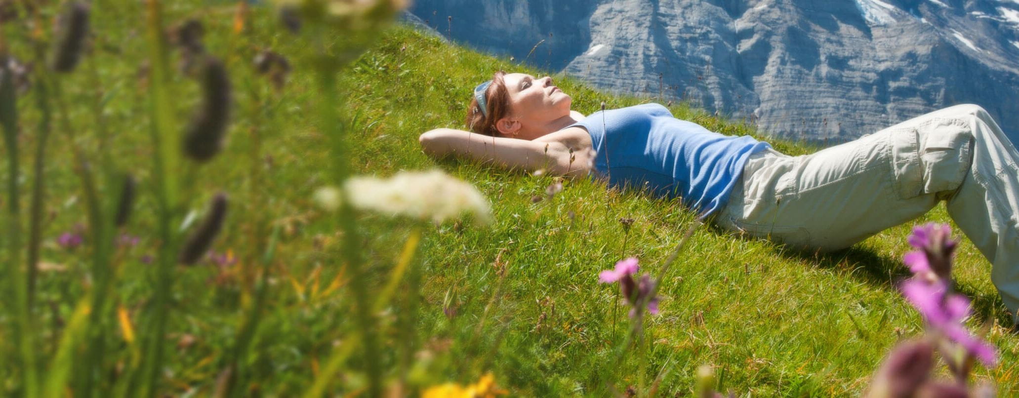 Frau liegt entspannt im Gras