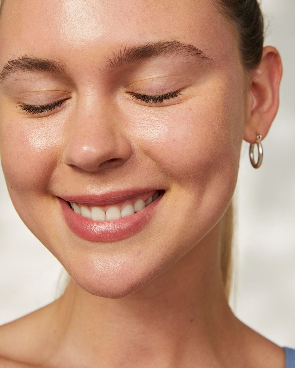Persona aplicando crema en su rostro