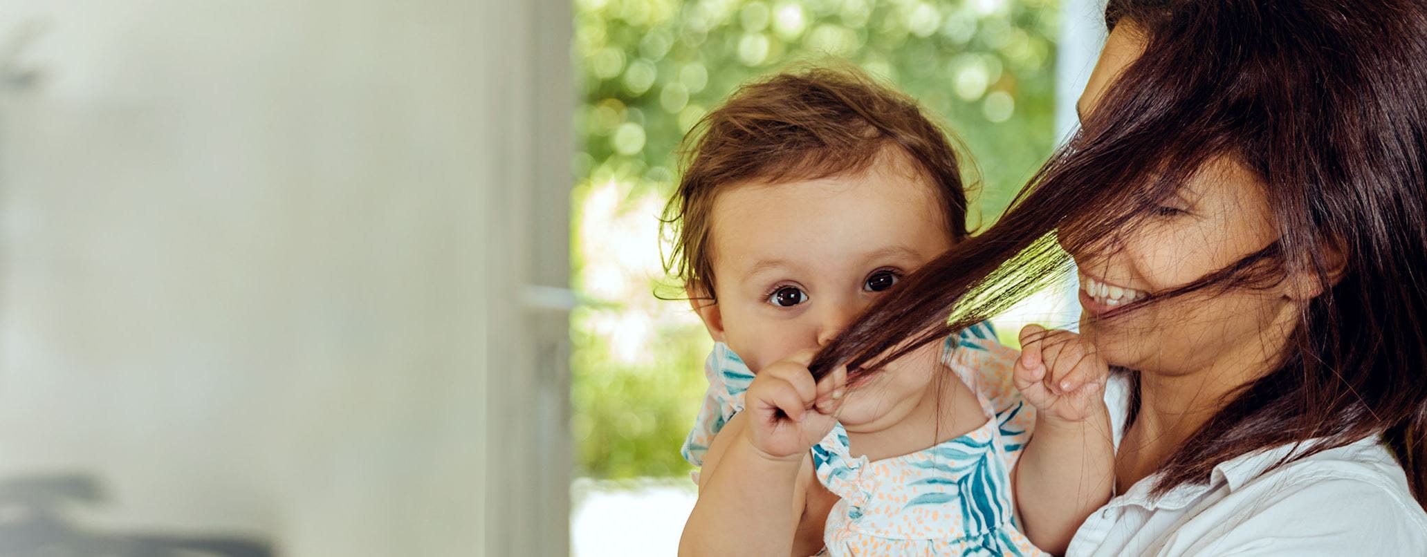 Baby zieht Mama an den Haaren