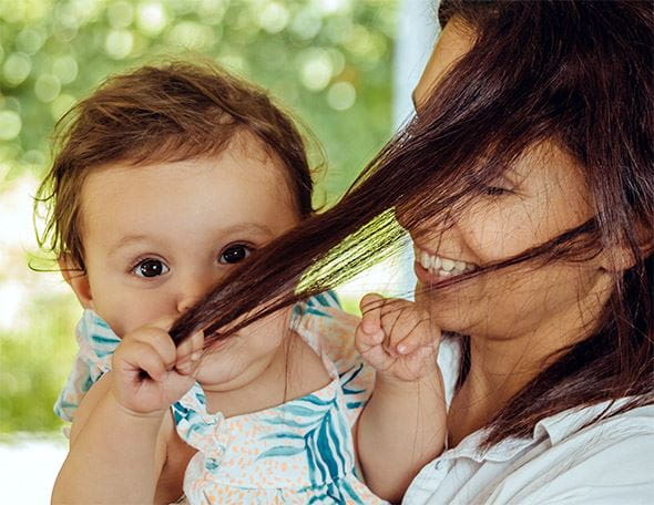 Baby zieht Mama an den Haaren