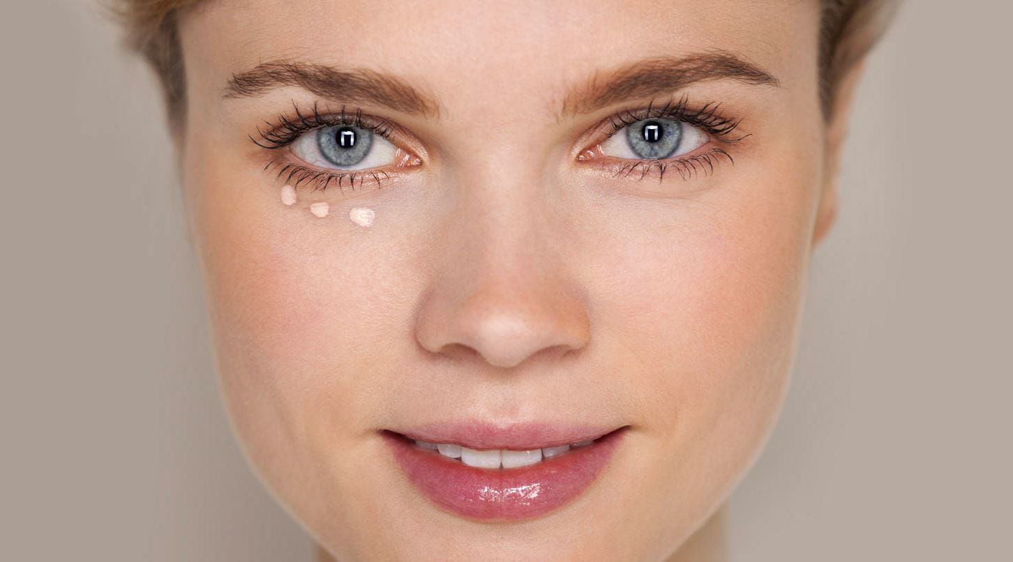 Frau mit Concealerpunkten unter einem Auge